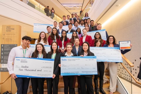 Tufts 100k New Ventures Competition  - Winner group picture with checks in the Joyce Cummings Center